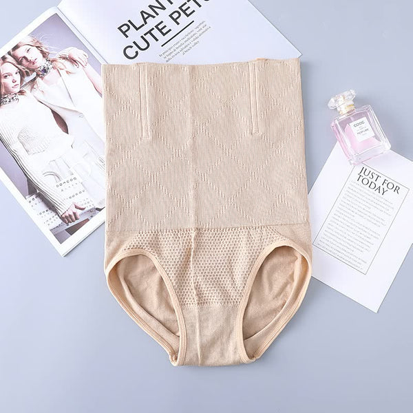 Beige corrigerend ondergoed voor dames op een grijze achtergrond, naast een parfumflesje en tijdschrift. Comfortabel, naadloos en ademend ontwerp.