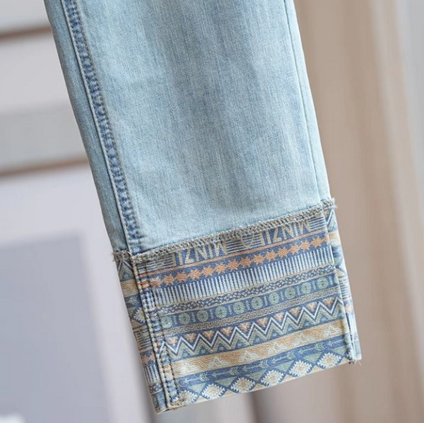 Lichtblauwe spijkerbroek met kleurrijke etnische print op de zoom, modieuze dameskleding, bohemian stijl, casual denim, trendy design.