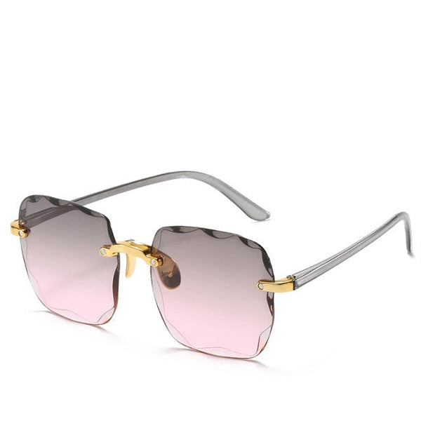 Roze zonnebril zonder montuur met gouden accenten en vierkante glazen. Trendy damesaccessoire voor zomer 2023. UV-bescherming, modieus design.
