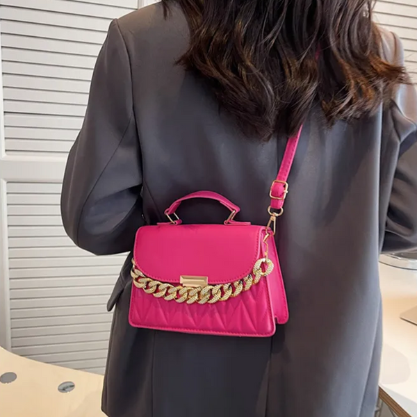 Vrouw met roze handtas met gouden ketting, gedragen over schouder. Stijlvolle modeaccessoire, perfect voor trendy outfits en dagelijkse elegantie.