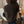 Vrouw met bruin gebreid vest en schoudertas in moderne kamer. Modieuze herfstkleding, casual stijl, comfortabele outfit.