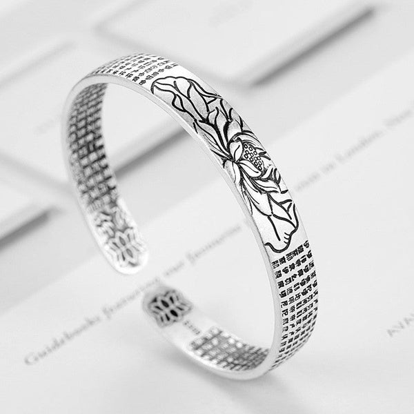 Zilveren armband met lotusgravure en boeddhistische teksten, elegant ontwerp, spirituele sieraden, ideaal voor meditatie en mindfulness.