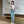 Vrouw in moderne woonkamer, draagt casual jeans en witte top, maakt selfie met smartphone. Stijlvolle interieurdecoratie, marmeren muur.