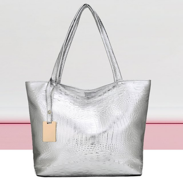 Zilveren krokodillenleren handtas met dubbele hengsels en beige label, stijlvolle damesaccessoire, modieuze tas voor dagelijks gebruik.
