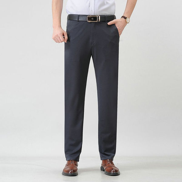 Donkergrijze herenbroek, formele stijl, gedragen met bruine leren schoenen en een witte overhemd. Ideaal voor zakelijke gelegenheden.