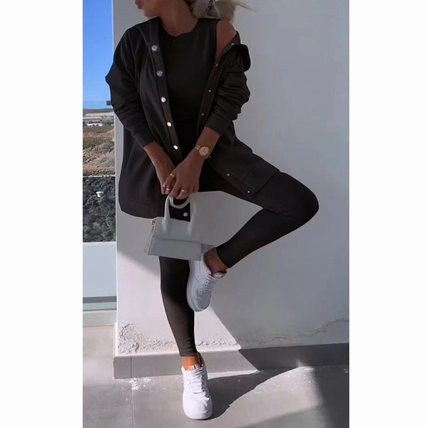 Vrouw in zwarte legging en oversized jas, witte sneakers, met kleine witte handtas. Modieuze casual outfit, stedelijke stijl, minimalistisch design.