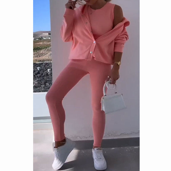 Vrouw in roze sportieve outfit met legging en vest, witte sneakers en kleine witte handtas. Modieuze dameskleding, casual en trendy stijl.