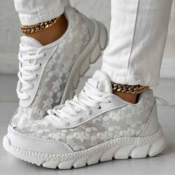 Witte damessneakers met bloemenpatroon en dikke zool, gecombineerd met gouden enkelketting. Modieuze sportschoenen voor casual en sportieve outfits.