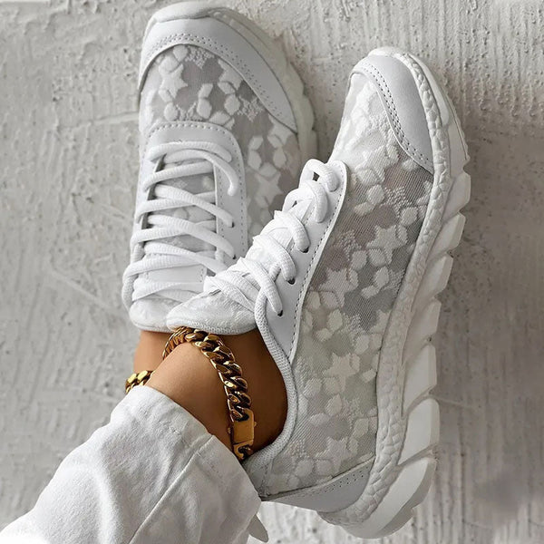 Witte sneakers met bloemenpatroon, gedragen door persoon met gouden enkelband. Modieuze dames schoenen, casual stijl, comfortabele pasvorm.