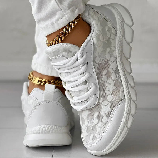 Witte damessneakers met bloemenpatroon, dikke zool en gouden enkelketting. Modieuze sportschoenen voor casual en sportieve outfits.