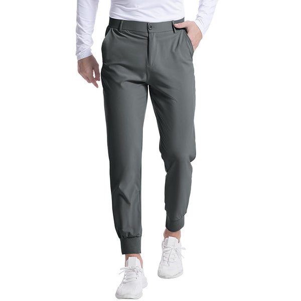 Donkergroene herenbroek met elastische tailleband en zakken, gedragen door model in witte sneakers en shirt. Comfortabele sportieve stijl.