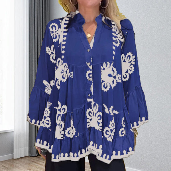 Blauwe boho blouse met witte bloemenprint, lange mouwen en knoopsluiting, gedragen door vrouw in moderne woonkamer. Trendy damesmode.