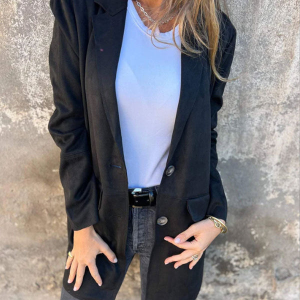 Vrouw in zwarte blazer en witte top tegen betonnen muur, casual mode, stijlvolle dameskleding, trendy outfit, moderne look, herfstmode.