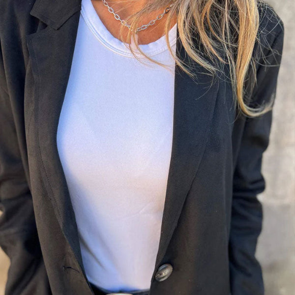 Vrouw in zwarte blazer en witte top, close-up. Modieuze dameskleding, casual chic stijl, perfect voor zakelijke en informele gelegenheden.