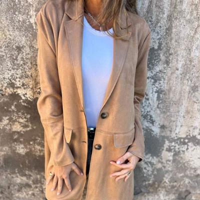 Vrouw in beige blazer en witte top tegen verweerde muur, modieuze herfstkleding, casual chic stijl, trendy damesmode, buitenfotografie.