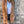 Vrouw in bruine suède blazer, witte top en zwarte jeans tegen betonnen muur. Modieuze herfstoutfit, casual chic stijl, dameskleding.