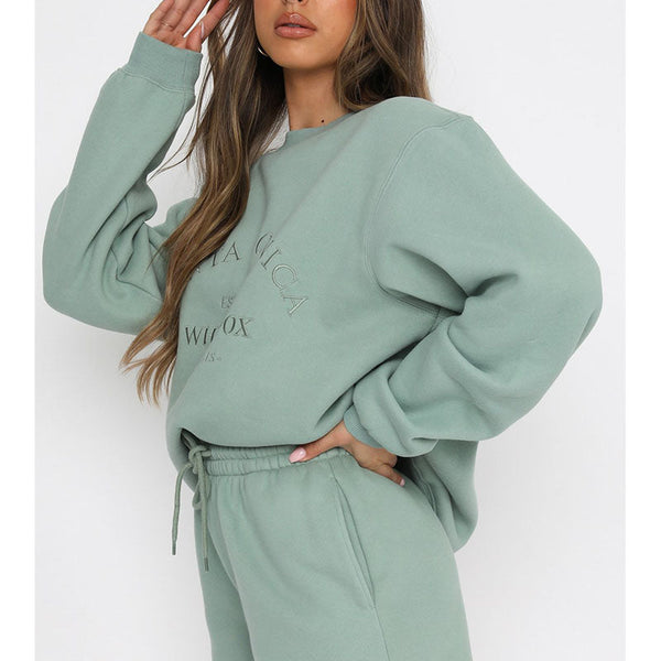 Groene oversized damestrui met opdruk, gecombineerd met bijpassende joggingbroek. Comfortabele loungewear, ideaal voor casual en trendy outfits.