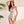 Vrouw in kleurrijke bloemenjurk, zomerse outfit, strandmode, witte achtergrond, tropische sfeer, trendy dameskleding, casual elegant.