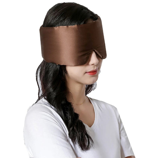 Vrouw draagt een bruine zijden slaapmasker, ideaal voor ontspanning en betere slaap. Comfortabel en stijlvol, perfect voor thuisgebruik en reizen.