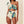 Vrouw in stijlvolle, asymmetrische bikini met kleurrijk patroon, hoge taille en ruches. Perfect voor strandmode en zomerse trends.
