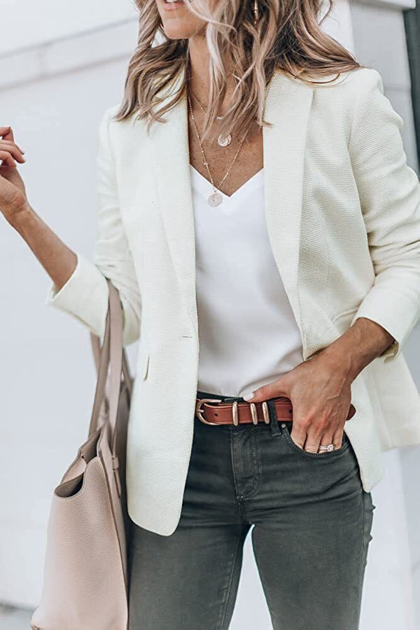 Vrouw in stijlvolle witte blazer, witte top en grijze jeans, draagt een beige tas. Mode, dameskleding, casual chic outfit.