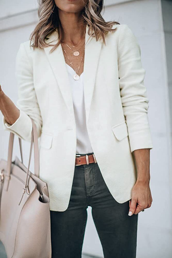 Vrouw in witte blazer met beige handtas, casual chique outfit, mode voorjaarslook, stijlvolle kleding, trendy damesmode, elegante stijl.