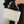 Witte leren handtas met geometrisch patroon, gouden kettingriem en zwarte jas. Stijlvolle damesmodeaccessoire, elegant en modern design.