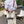 Man met witte canvas schoudertas met rode accenten, staand op een zonnige straat met opvouwbare stoelen. Stijlvolle zomermode accessoire.