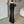 Vrouw in zwarte flared broek, witte top, zwarte schoudertas. Stijlvolle mode, trendy outfit, casual chique look, moderne kledingstijl.